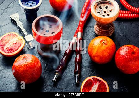 Orientalisch rauchender Shisha oder Shisha mit Tabak mit Grapefruitgeschmack.Modern Obstshisha mit Orange Stockfoto