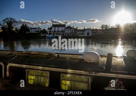 Ein schmales Boot liegt auf der Themse in Staines-upon-Thames, Surrey, Großbritannien. Stockfoto