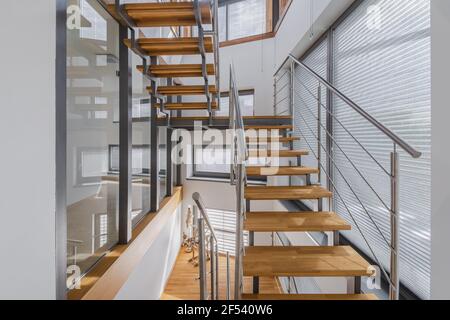 Innen mit Holztreppen und großen Fenstern Stockfoto