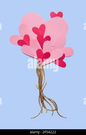 Pinke Papierherzen auf Fäden. Luftballons in Form von Herzen. Valentinstag-Konzept. Stockfoto