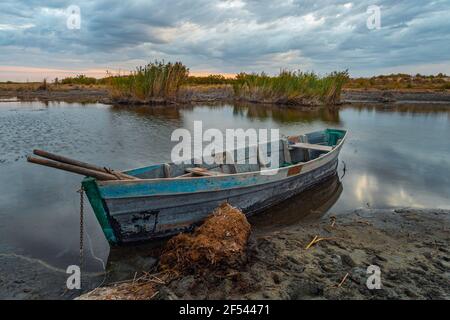 Altes Fischerboot aus Holz auf dem See. Herbstlandschaft. Traditionelles hausgemachtes Holzboot mit flachem Boden Stockfoto