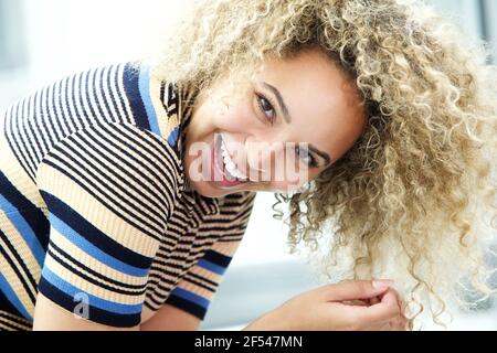 Nahaufnahme Porträt der lachenden jungen schwarzen Frau über lehnt Stockfoto