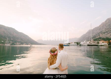 Die Braut in einem Kranz und Bräutigam Umarmung auf dem Pier in der Nähe der Altstadt von Kotor in der Bucht von Kotor, Nahaufnahme Stockfoto