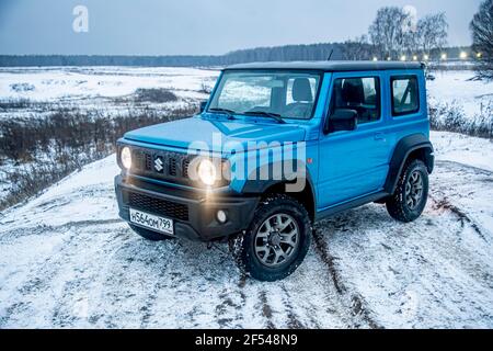 Moskau, Russland - 24. Januar 2020: Neuer Suzuki Jimny Mini-SUV auf Winterstraße am Abend. Japanische Suzuki SUV mit Scheinwerfer an. Keine Menschen. Stockfoto