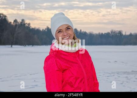 Ältere Frau, die im Winterwald steht und sich nach dem Training ausruhte Stockfoto