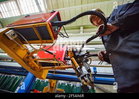 Ekibastuz, Region Pavlodar, Kasachstan Mai 28 2012: Wagenbauwerk. Schweißer mit automatischer Schweißmaschine. Stockfoto