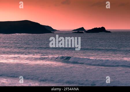 Abendlicht über Pentire Point East und den beiden felsigen Inseln The Goose and the Chick in Fistral Bay in Newquay in Cornwall. Stockfoto