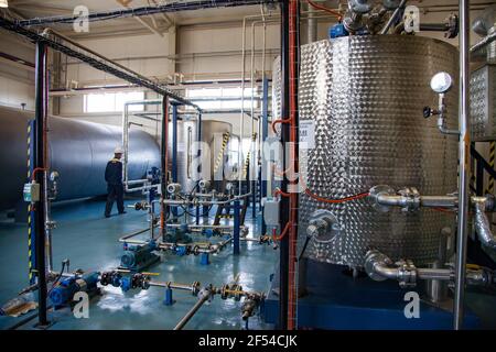 Ekibastuz, Kasachstan - 28. Mai 2012. Explosives Material. Chemielager, Reaktortank und Arbeiter im Hintergrund. Fokus auf rechten Tank. Stockfoto