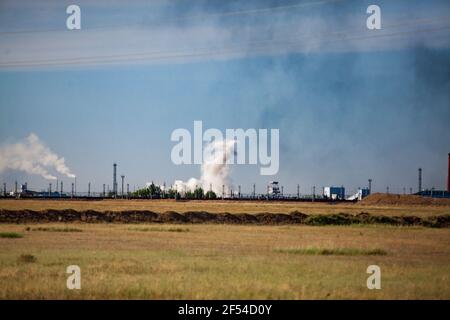 Panoramablick auf Steppe und Explosion. Weiße Wolke und schwarzer Rauch. Steinbruch in Kasachstan. Stockfoto