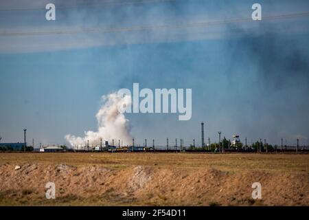 Panoramablick auf Steppe und Explosion. Weiße Wolke und schwarzer Rauch. Steinbruch in Kasachstan. Stockfoto