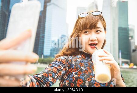 Hübsche asiatische Frau Wanderer nimmt Selfie in modernen städtischen Bereich Von Marina Bay auf Singapur Skyline bei Sonnenuntergang - Abenteuer Reiselebensstil Stockfoto