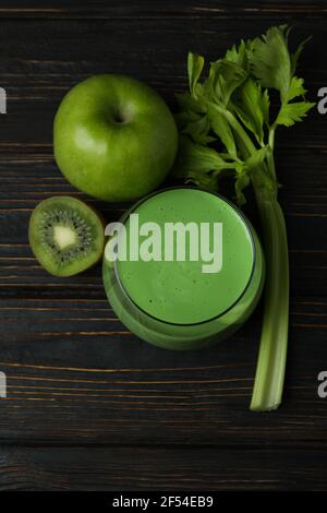 Glas grüner Smoothie und Zutaten auf Holztisch Stockfoto