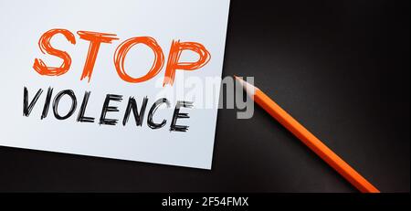 Stop Violence Text mit orangefarbenem Bleistift auf Papier schreiben. Kein diskriminierender sozialer Begriff Stockfoto