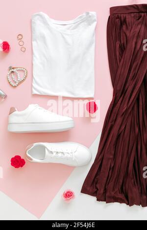 Weiblich Frühling Look Sommer Outfit Rock Schuhe Sneaker Basic T-Shirt Tasche. Gefaltete Kleidung für Frauen Mode städtischen Basic-Outfit mit Accessoires Blumen Stockfoto