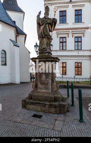 Statue des Heiligen Patrick auf Masarykovo namesti Platz mit Kostel Povyseni sv. Krize churh auf dem Hintergrund in Karvina Stadt in Tschechien Stockfoto