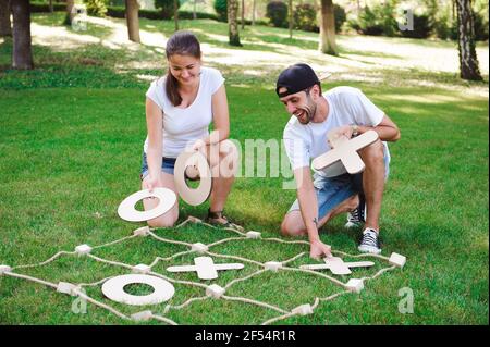 Big Tic Tac Toe Spiel. Guy und Mädchen spielen im Freien. Stockfoto