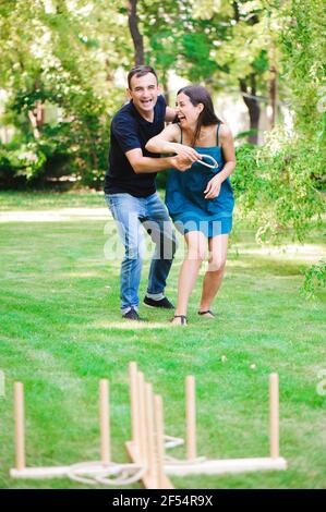 Freunde Flechten Spiele im Freien - Ring werfen im Sommerpark. Stockfoto