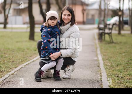 Mutter und Tochter gehen im Park während der Qurantine. Glückliche Familie atmen frische Luft Stockfoto