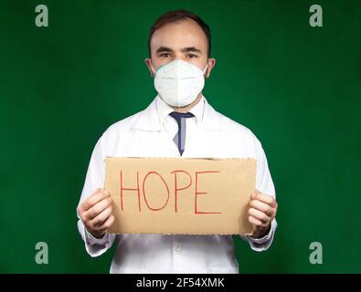 Arzt hält ein Zeichen mit dem Wort "Hoffnung" für die Aufrechterhaltung Hoffnung und Glaube inmitten von covid-19 Stockfoto