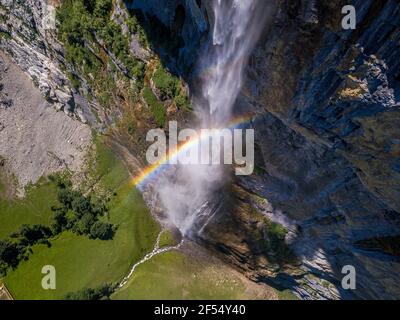 Majestätische Luftaufnahme eines Regenbogens über dem großen Wasserfall In Lauterbrunnen Dorf in der Schweiz Stockfoto