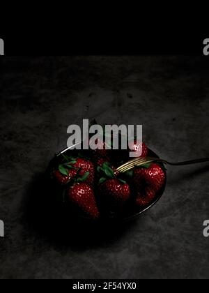 Frische Erdbeeren in einer Schüssel. Dunkles Essen. Stockfoto