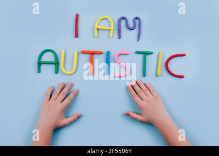 World Autism Awareness Day Konzept - bunte Buchstaben, bin ich autistic - Kinderhände spielen vor blauem Hintergrund. Autismus-Spektrum-Störung und Stockfoto
