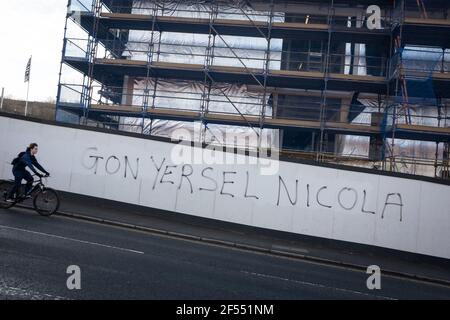 Glasgow, Großbritannien, am 24. März 2021. ÔGon yersel NicolaÕ Graffiti erscheint zur Unterstützung von First Minister Nicola Sturgeon auf einer Baustellenmauer, als die schottischen politischen Parteien ihre Kampagne für die Wahlen zum schottischen Parlament am 6th. Mai beginnen. Foto: Jeremy Sutton-Hibbert/Alamy Live News. Stockfoto