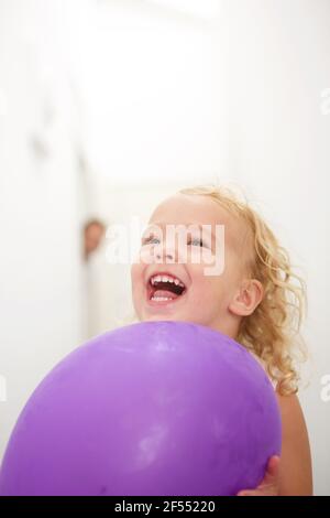 Nahaufnahme Porträt von niedlichen kleinen Mädchen hält Ballon und Lachend Stockfoto