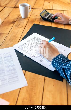 Männliche Steuerzahler, die individuelle Einkommenssteuererklärung ausfüllen Stockfoto