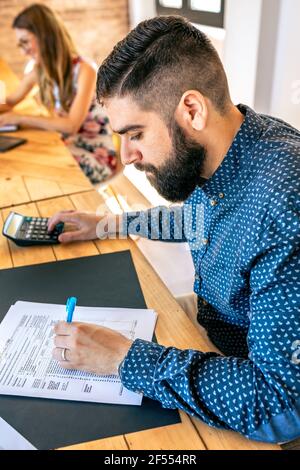 Berater Ausfüllen von Steuerunterlagen im Büro Stockfoto