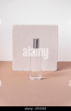 Flasche natürliches Hautpflegeprodukt, Vorderansicht. Beauty-Kosmetik, Hautpflege-Konzept. Grauer Steinhintergrund. Stockfoto