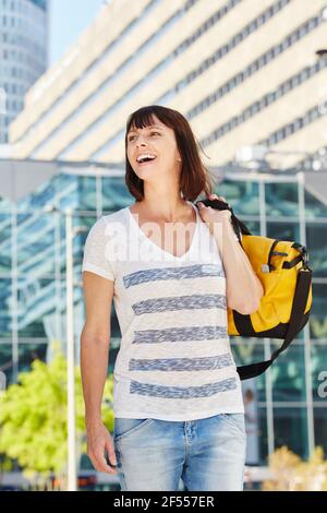 Porträt einer glücklichen älteren Frau, die eine Seesasche über der Schulter trägt Stockfoto