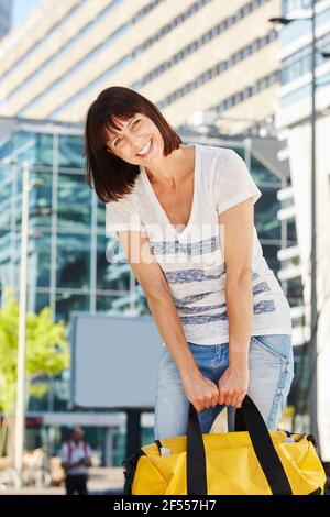 Porträt eines älteren Reisenden, der schwere Reisetasche draußen trägt Stockfoto