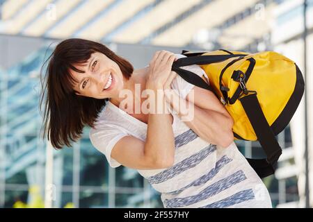Porträt des glücklichen Reisenden mit Reisetasche über der Schulter Stockfoto