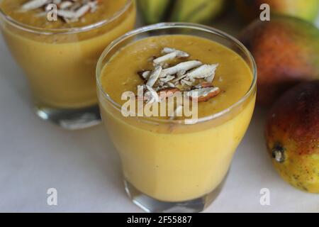 Mango Banana Smoothie, EIN köstlich dicker und cremiger Bananenmoothie, der mit Mango-Geschmack strotzt. Hergestellt mit nur 5 einfachen Zutaten. Auf Weiß geschossen Stockfoto