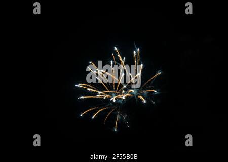 Einfache Feuerwerkskörper gegen den Nachthimmel, explosive pyrotechnische Geräte, die für feierliche Zwecke verwendet werden, am Ende von Partys oder Festen Stockfoto