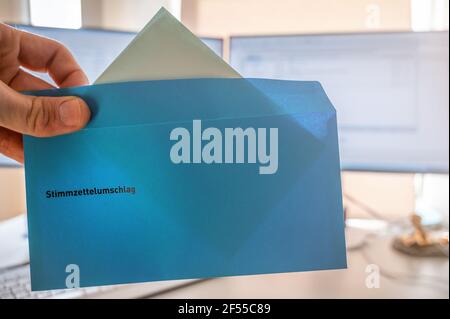 Eine Stimme bei der Wahl für den neuen Stab abzugeben rat mit einem Umschlag als Briefwahl mit dem Wort Stimmumschlag in deutscher Sprache Stockfoto