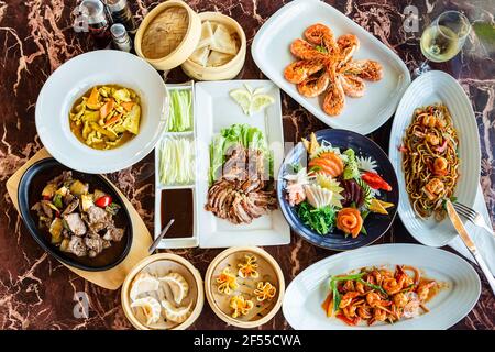 Auswahl an chinesischen Speisen, japanisches traditionelles Sushi-Essen auf Marmorboden. Blick von oben, flach liegend Stockfoto