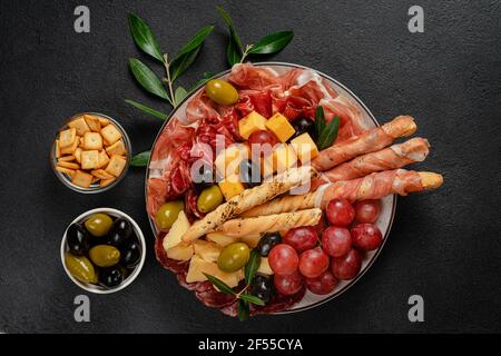 Verschiedene italienische Antipasto auf schwarzem Hintergrund, direkt darüber gesetzt. Stockfoto