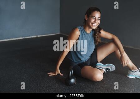 Aktives Lifestyle- und Sportkonzept. Happy Gorgeous fit Sportlerin Sportbekleidung, motiviertes gutes Training Fitness-Session, Ruhe auf Turnhalle Boden Stockfoto