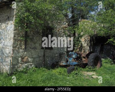 Blick auf rostigen alten Traktor vor verlassenen Stein Bauernhof Gebäude im Tatoi Park in der Nähe von Athen, Griechenland. Stockfoto