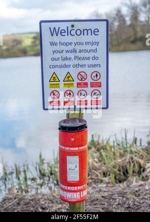 Kilnwick Percy, East Yorkshire, England, 16. Februar 2021 - lebensrettende Ausrüstung auf einem Pfosten neben einem See mit vielen Informationssymbolen. Stockfoto