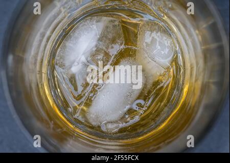 Glas mit Whiskey auf den Felsen als Hintergrund im Detail Stockfoto