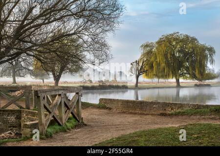 Weg zwischen zwei Teichen durch alte Holzbrücke am buschigen ParkAn einem nebligen Morgen im März. Wenn auf öffentlichen oder privaten Grundstück bin ich bereit, volle r nehmen Stockfoto