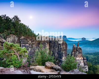 Feuchte Nacht mit dem Mond im Sonnenlicht zerklüftete Sandsteinwände im Nationalpark Sächsische Schweiz. Stockfoto