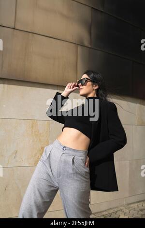 Frau, die die Sonnenbrille anpasst, während sie sich nach hinten beugt Stockfoto