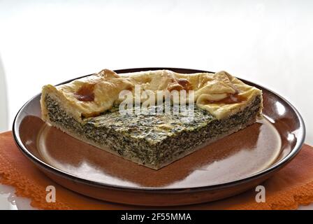 torta salata di Pasta sfoglia con spinaci e uova fetta Nel piatto di coccio Primo Klavier Stockfoto