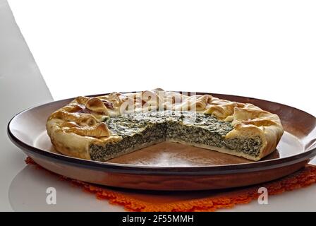 torta salata di Pasta sfoglia con spinaci e uova tagliata Nel piatto di coccio Primo Piano altra vista Stockfoto