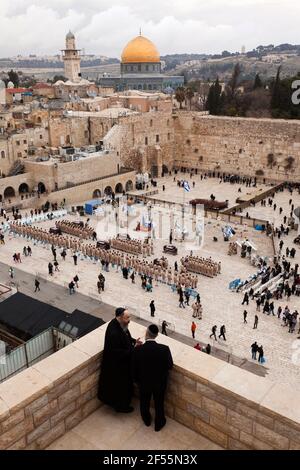 Israel, Jerusalem, zwei Rabbiner im Überblick über den Felsendom und die Klagemauer, Militärparade auf dem Platz. Stockfoto