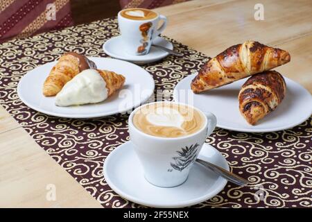 Kaffee-Frühstück mit drei Arten von Croissants in einem Tisch Hintergrund Stockfoto